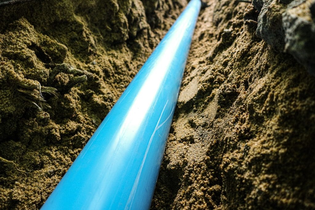 Close up pvc pipe under backfilling ground